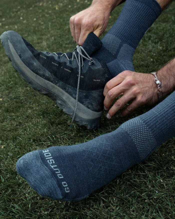 Man putting on shoes wearing crew socks