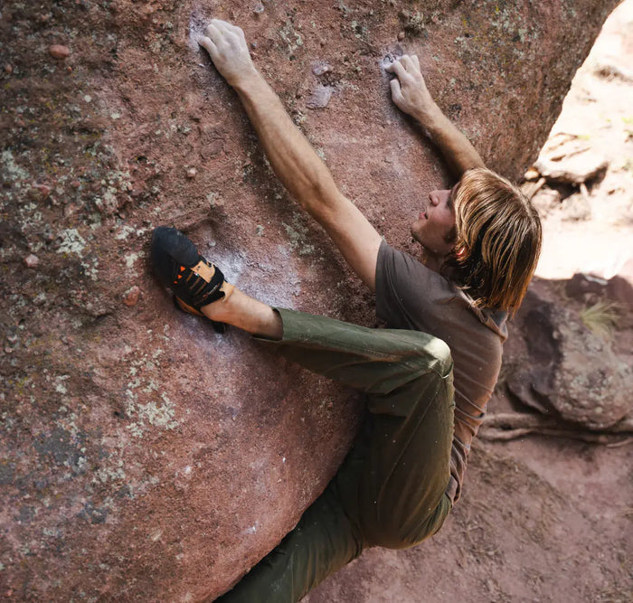 Man wearing brown alpaca tee shirt climbing