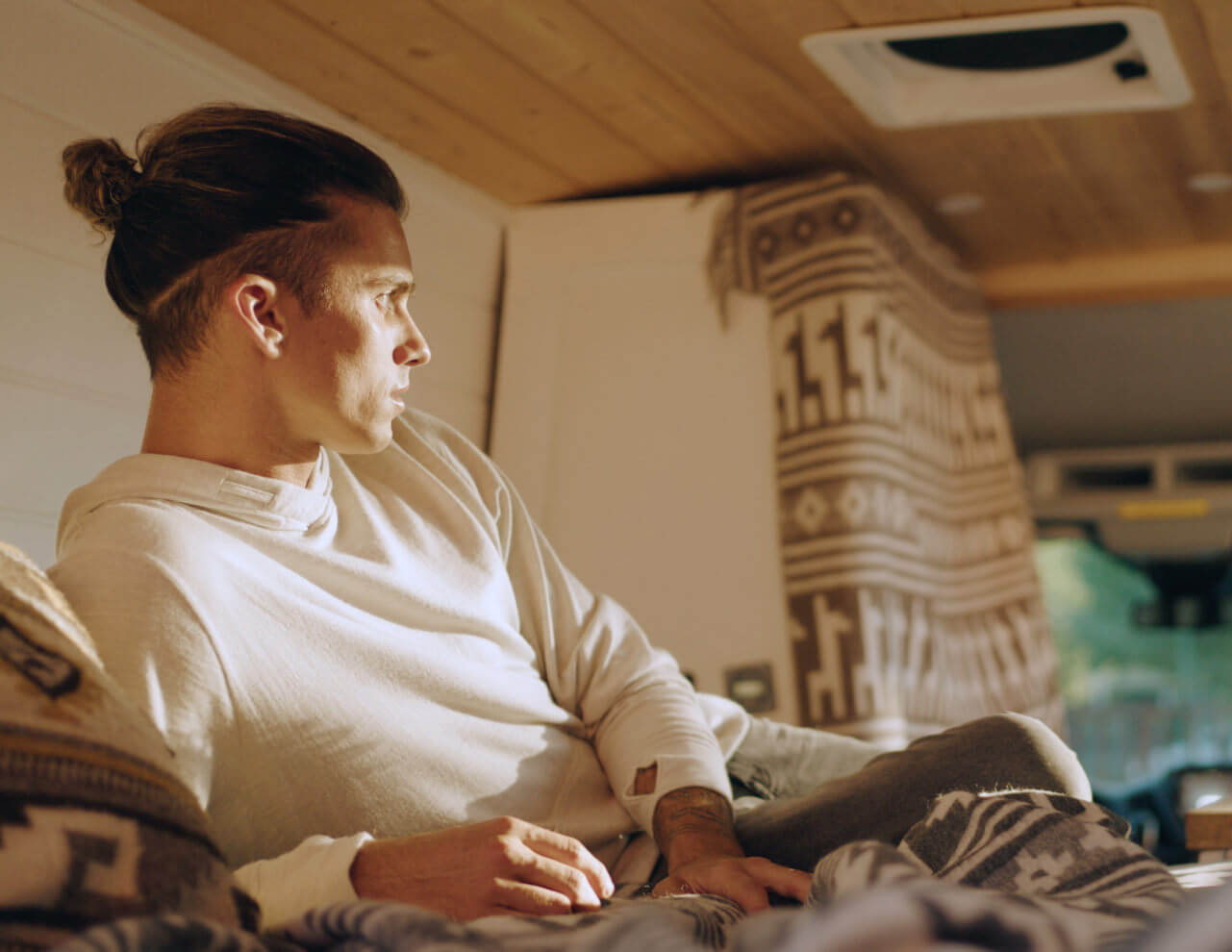 Man in Alpaca Wool Hoodie in Campervan Looking Outside Toward the Sun - PAKA Apparel