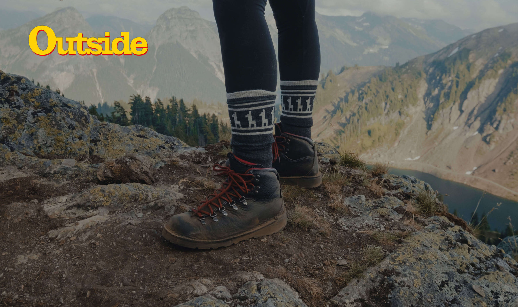 A lady over a rock wearing our cozy alpaca Costa socks 