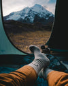 Grey Peruvian Alpaca Wool Socks on Feet Resting Inside Tent with View of Snow-Covered Mountains – PAKA Apparel