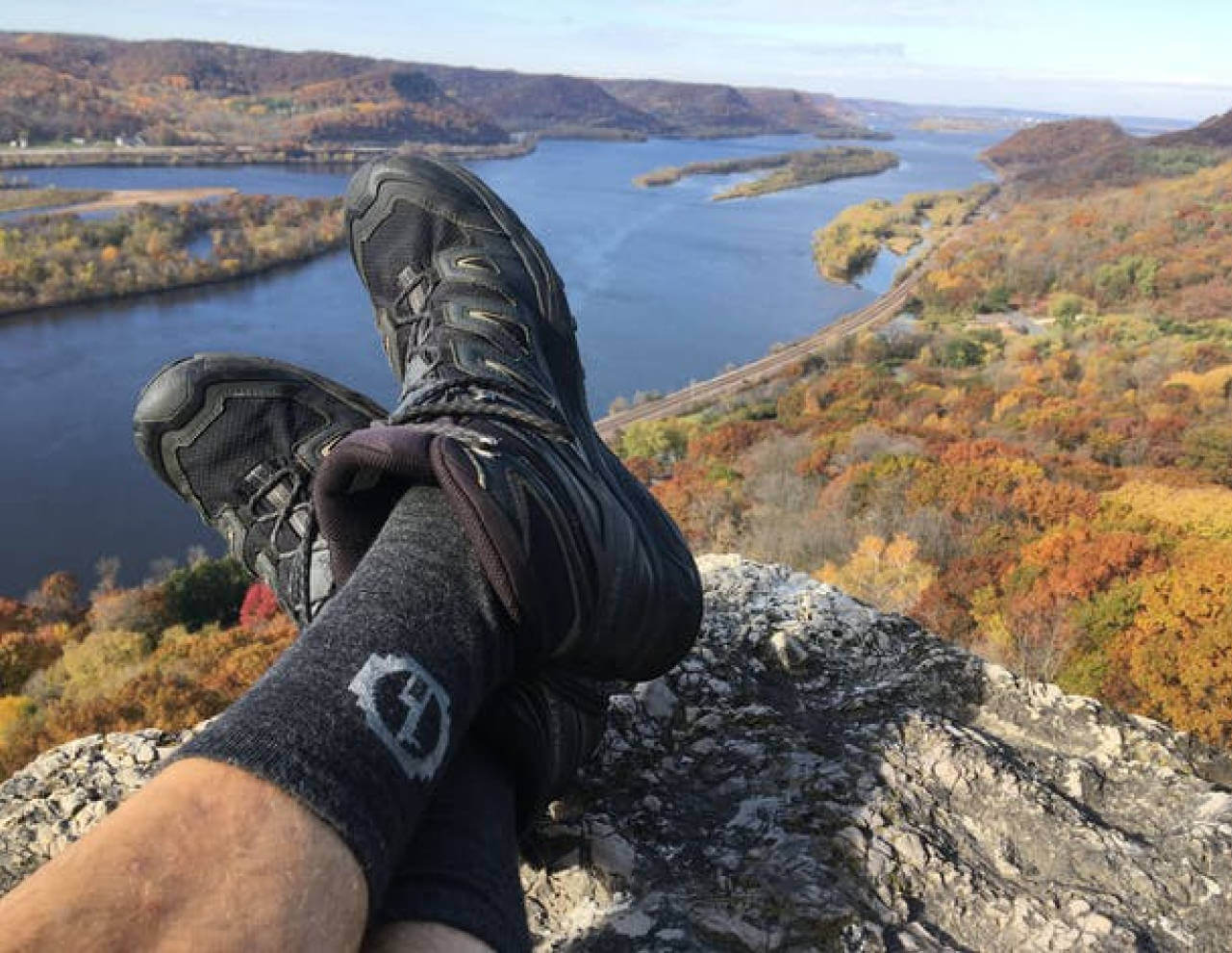 Man’s Legs with Alpaca Wool Crew Socks and Hiking Boots from Rocky Overlook of Waterway and Hills - PAKA Apparel