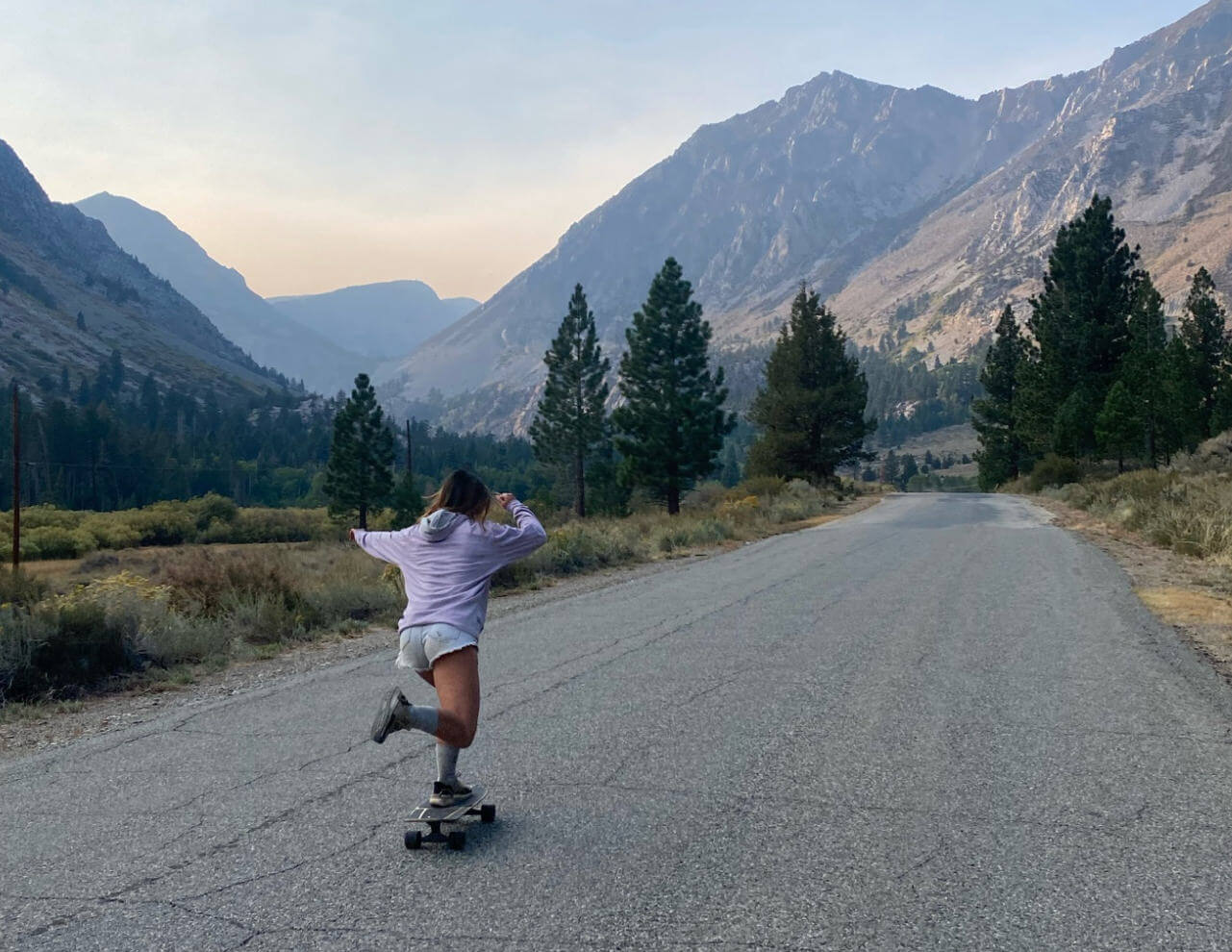 Woman Skateboarding on Mountain Road While Wearing Alpaca Activewear - PAKA Apparel