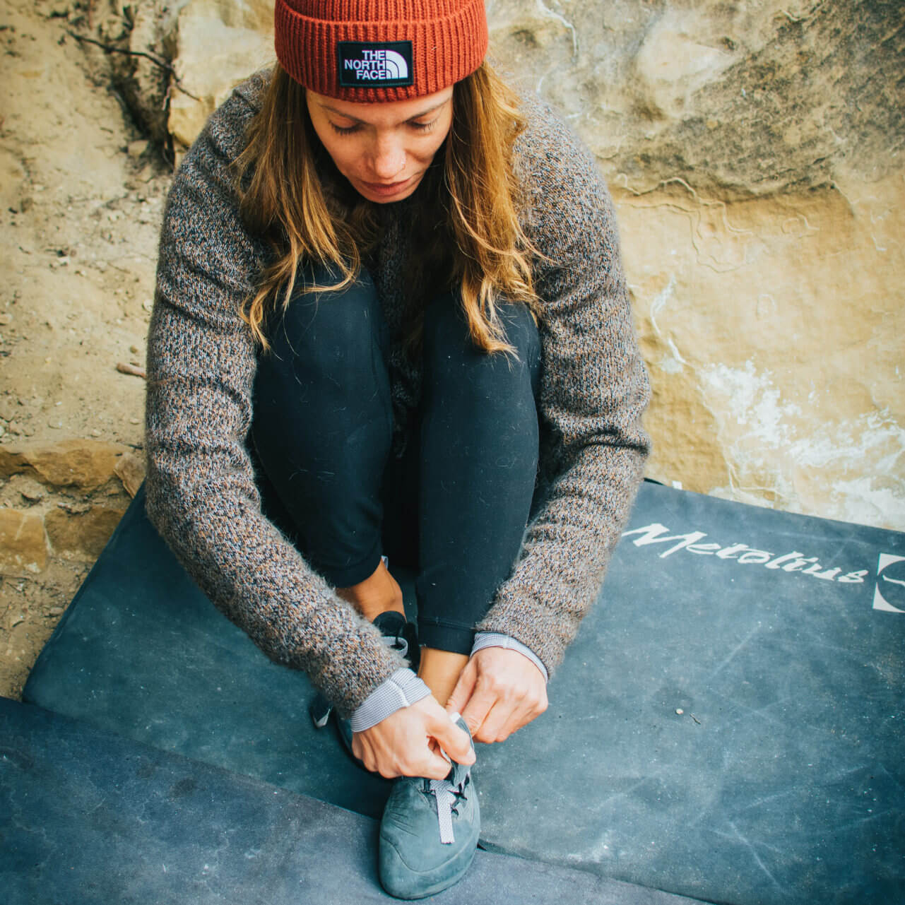 Woman Climber Wearing Alpaca Sweater Putting on Climbing Shoes - PAKA Apparel