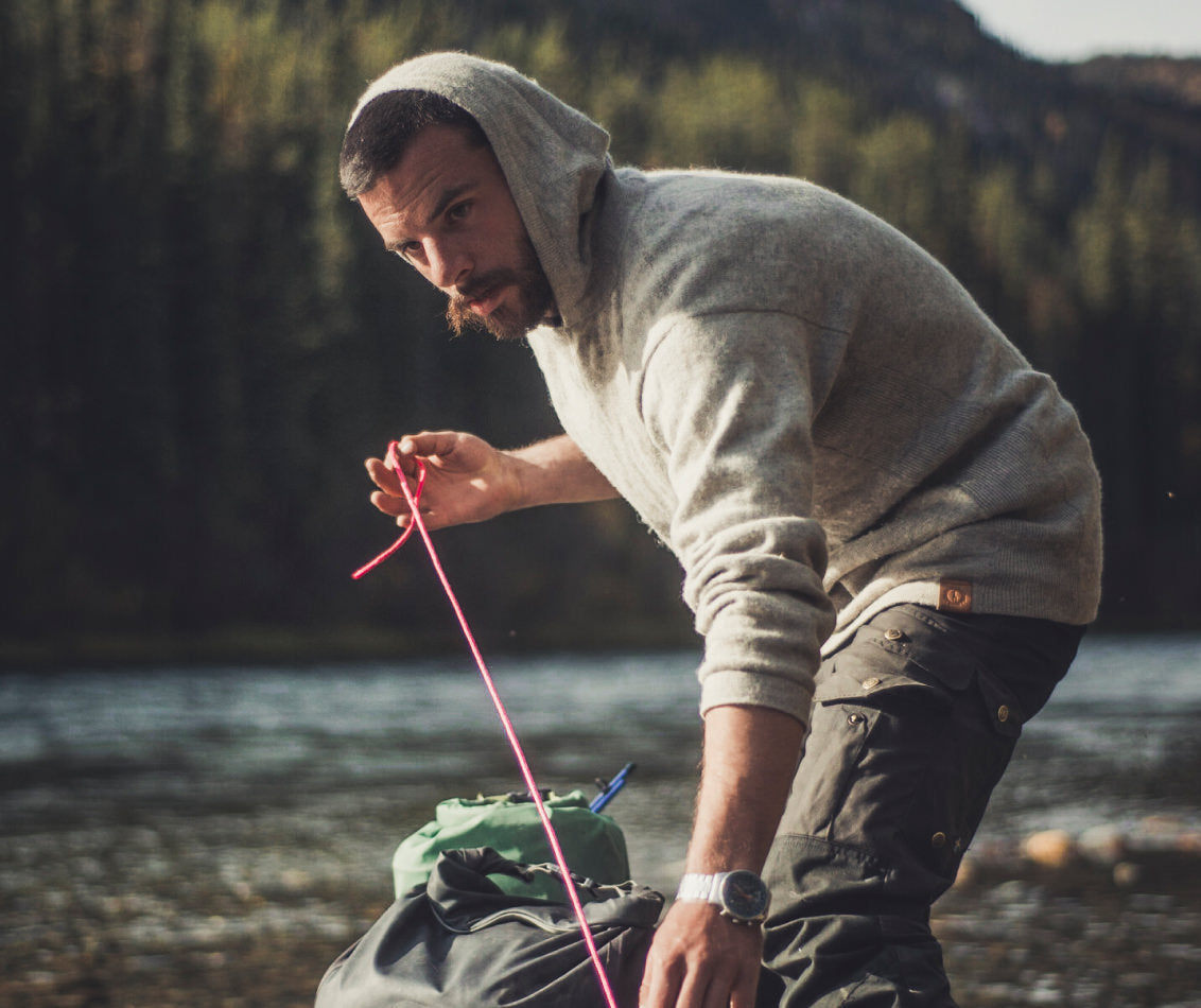 Man in Light Grey The Original Alpaca Wool Hoodie with Fishing Gear in Front of River - PAKA Apparel