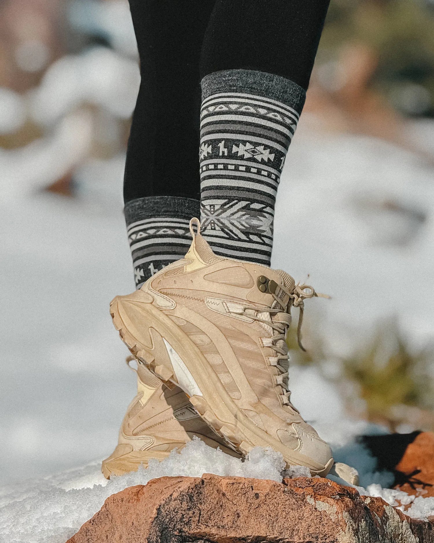 Alpaca Wool Socks with Inca Crew Design in Charcoal Grey Worn with Hiking Boots on Snowy Rock – PAKA Apparel