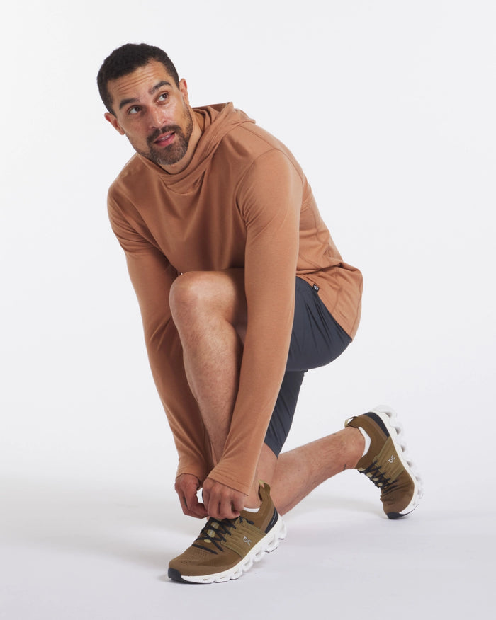 Man tying shoes while wearing Men's Sol Hoodie