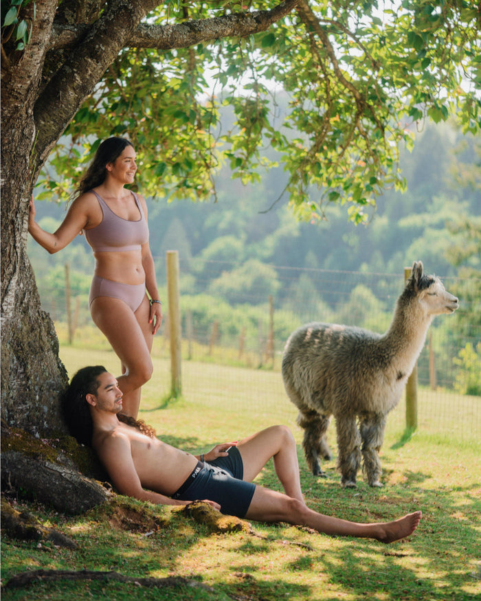 Woman and Man in Sustainable Natural Fiber Underwear by a Tree with an Alpaca – PAKA Apparel