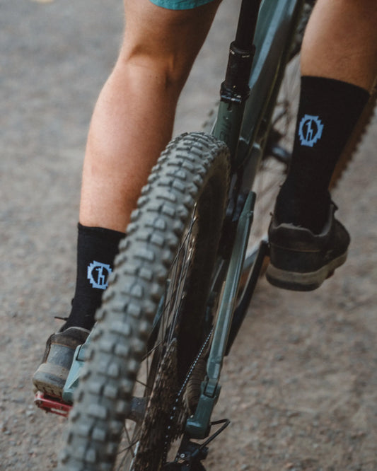 Man mountain biking wearing black alpaca wool sock