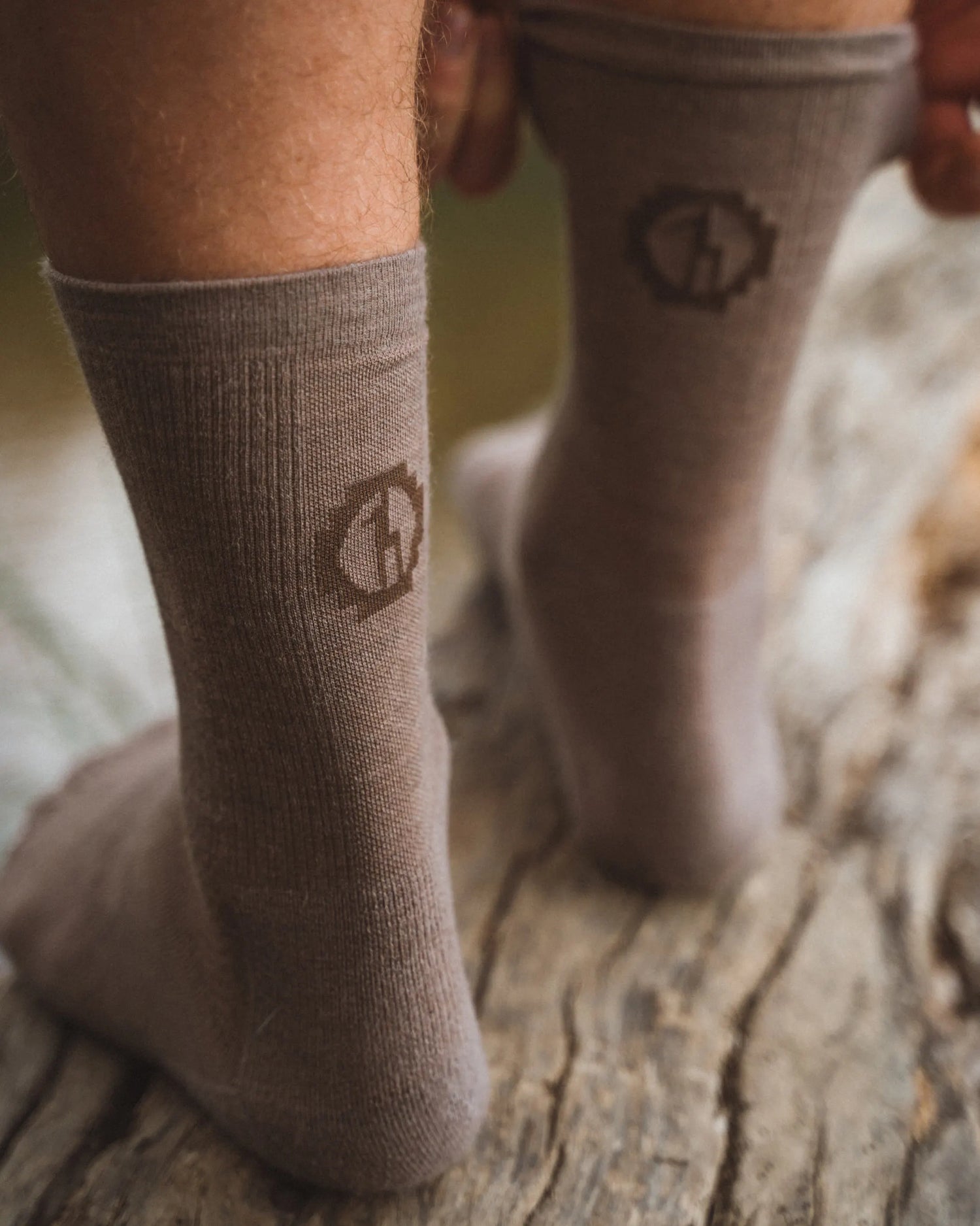 Back of Man's Legs Standing on Log Wearing Walnut / Tan Trail Sustainable Alpaca Wool Crew Socks – PAKA Apparel