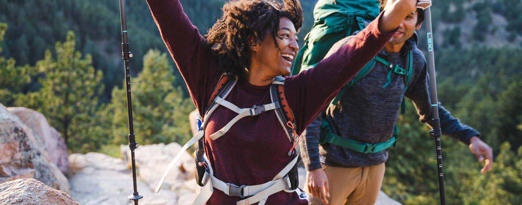 Woman with Hiking Poles Celebrating in Burgundy / Dark Red Alpaca Wool Hiking Sweater with Man in Background – PAKA Apparel