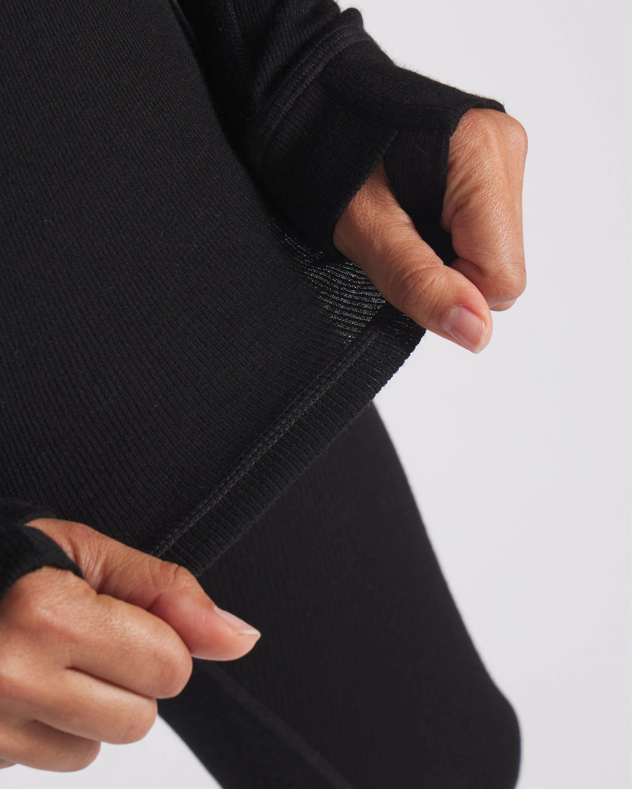 Close-Up of Woman Stretching Waist of Black Alpaca Wool Thermal Long Underwear Top – PAKA Apparel