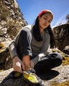 Woman Putting on Climbing Shoe in Mountains Wearing Eucalyptus / Green Everyday Lightweight Alpaca Wool Baselayer Top – PAKA Apparel