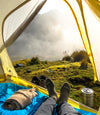 Alpaca socks next to alpaca sweater with view from tent camping 