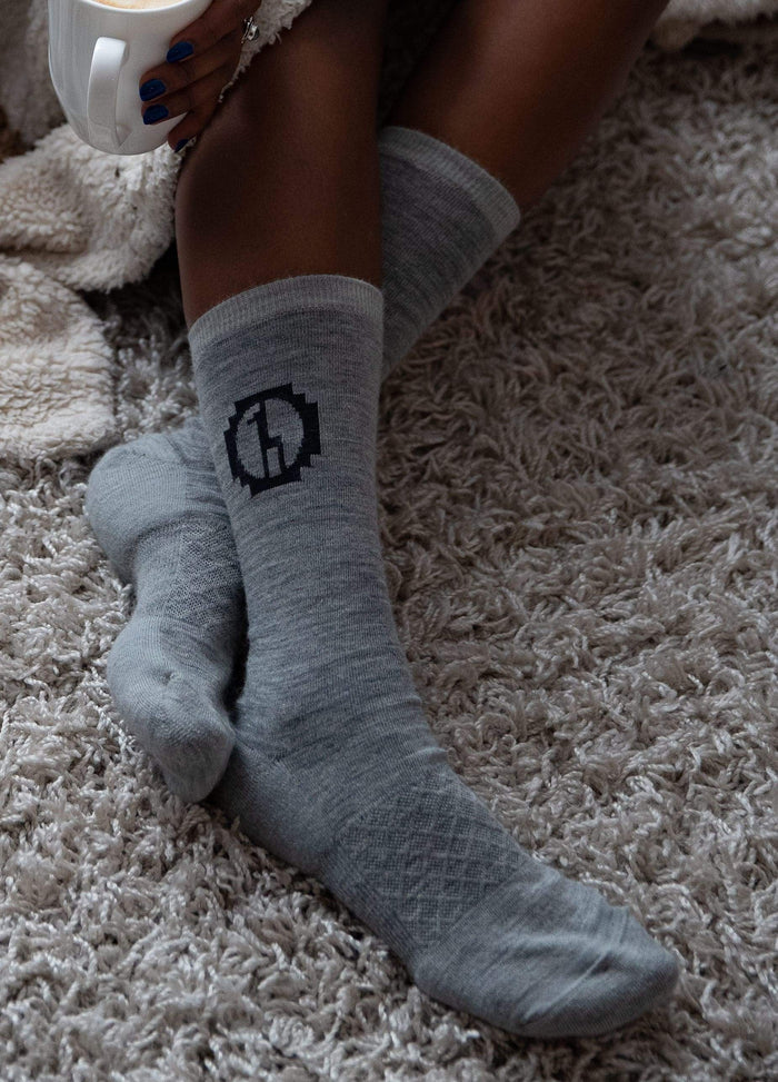 Baby alpaca socks on rug with woman  model legs and coffee