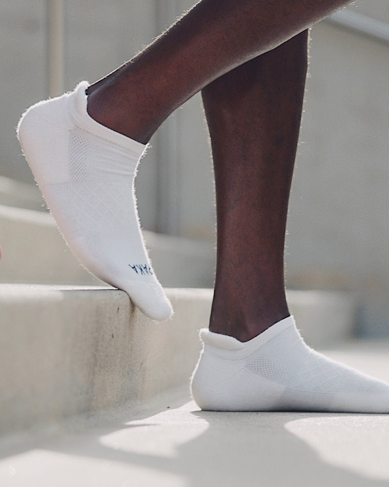 Man walking down steps wearing white alpaca wool ankle socks 