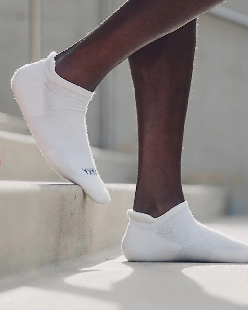 Man walking down steps wearing white alpaca wool ankle socks