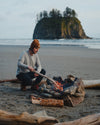 Men's grey alpaca wool base layer on model sitting near bon fire