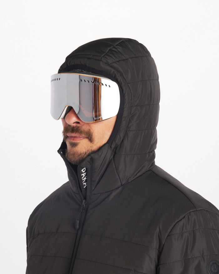 Male Model Wearing Ski Goggles with Hood Up in Apu Matte Black Men’s Breathable Midweight Puffer Jacket with Natural Fiber Insulation  – PAKA Apparel