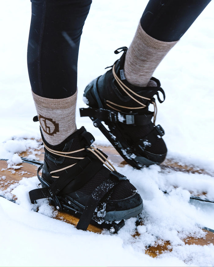 Tan alpaca wool alpaca socks on model snowshoeing 