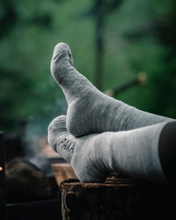 Light grey Paka socks on wooden stump on woman model