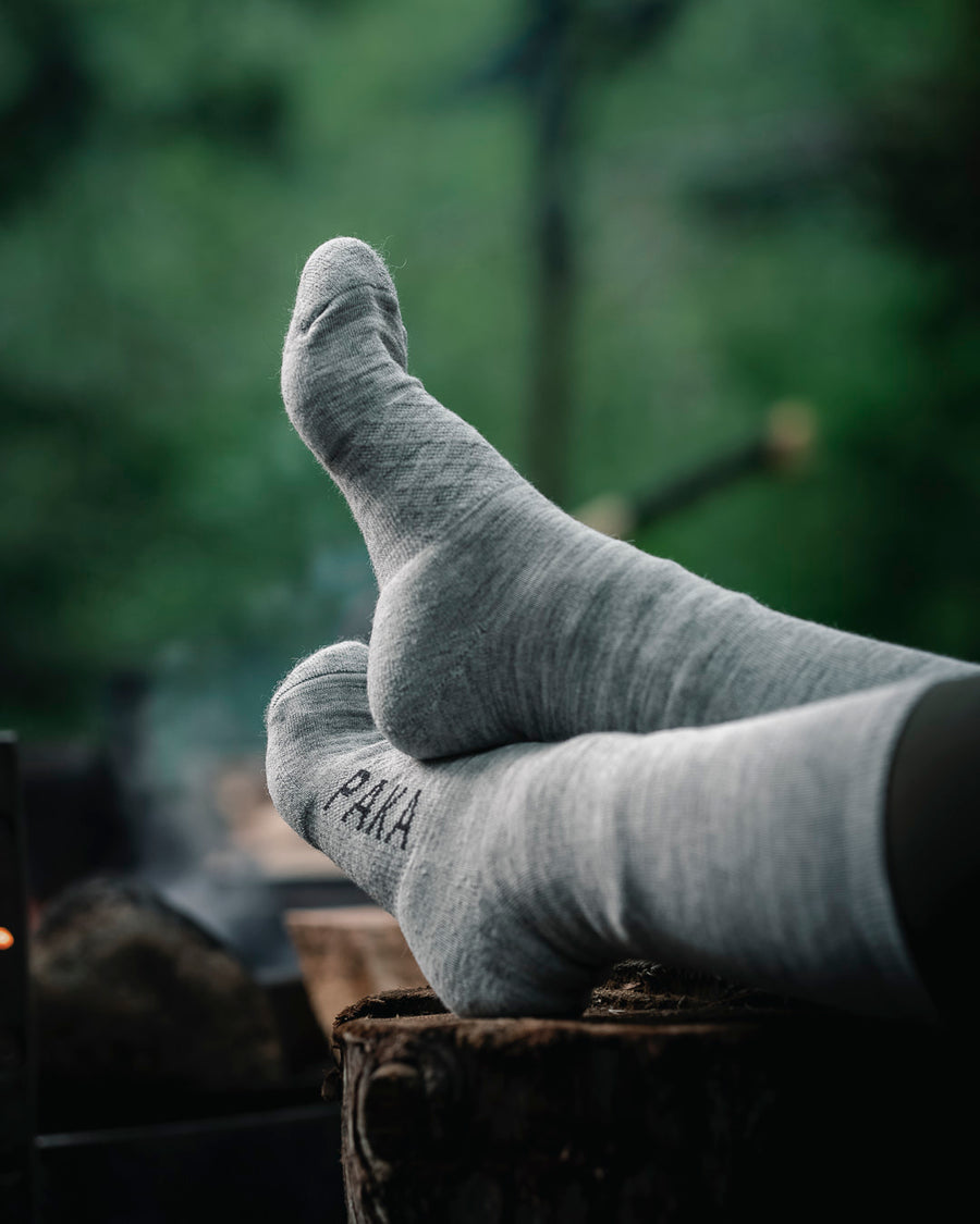 Light grey Paka socks on wooden stump on woman model