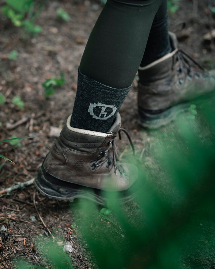 Woman Model walking in dark grey Paka socks and boots on a trail