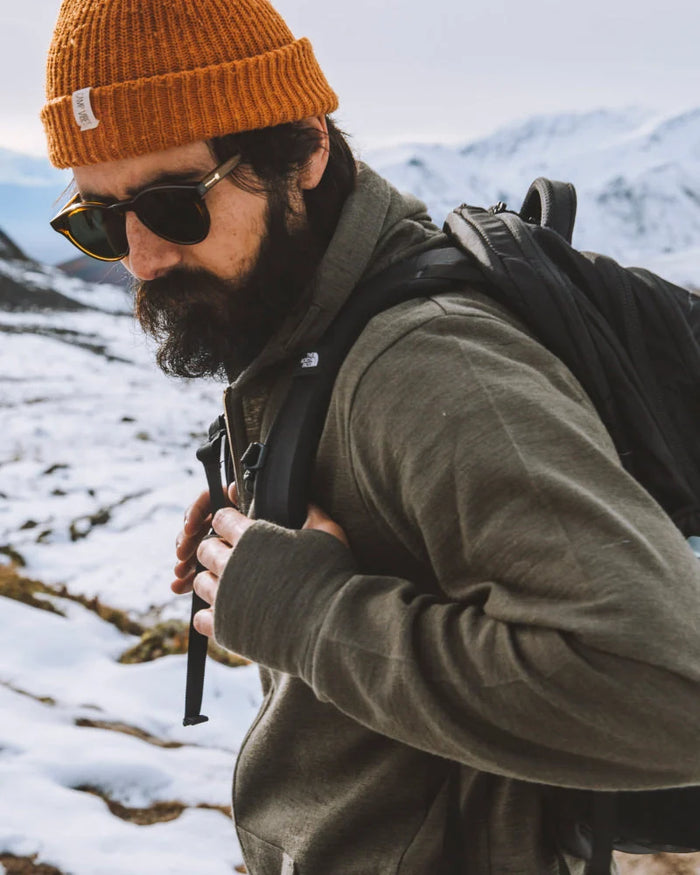 Men walking through snow with green alpaca hoodie 