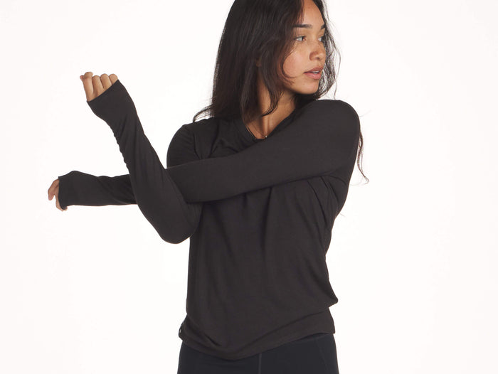 Woman stretching in black Women's Everyday Baselayer