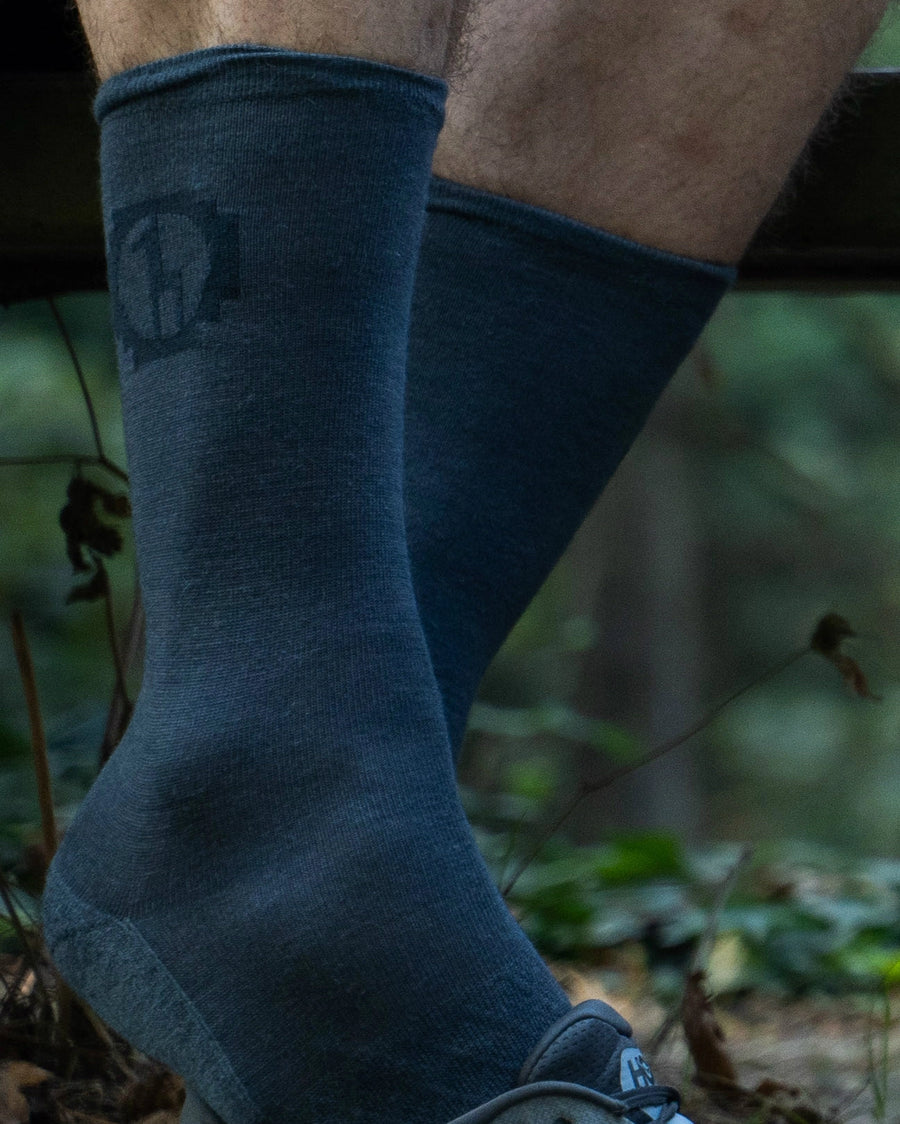 Indigo / Blue Lightweight Alpaca Wool Crew Socks on Pair of Legs in Forest – PAKA Apparel on male model