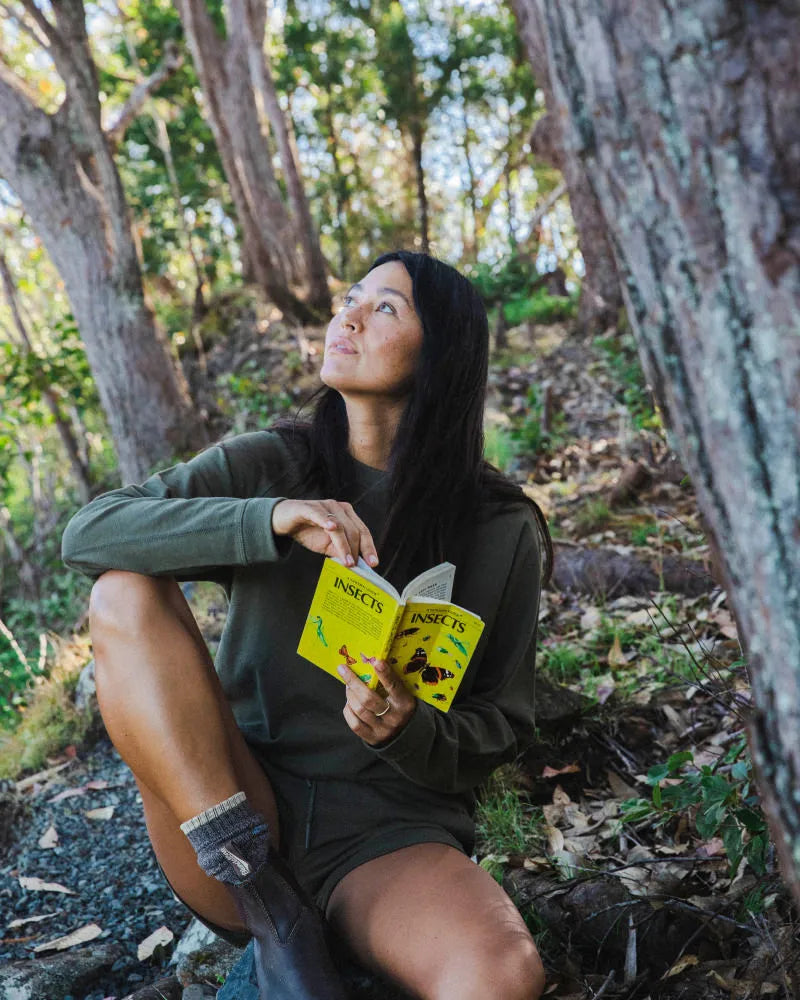 Woman Sitting in Forest with Book Wearing Andean Moss Green Alpaca Tri-Blend Terry Crewneck Long Sleeve Shirt – PAKA Apparel